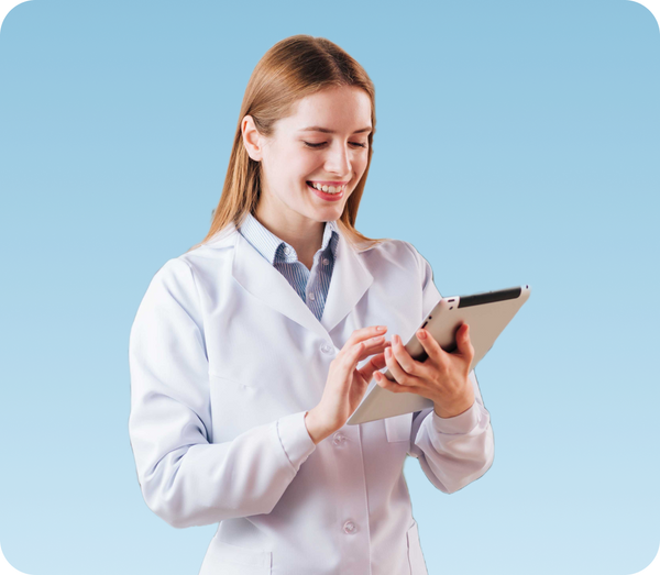 Smilende kvinde i hvid kittel bruger en tablet.
